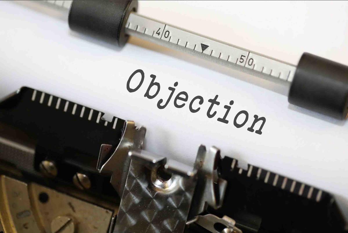 an example to signify objections in sales. a type writer with the word objection